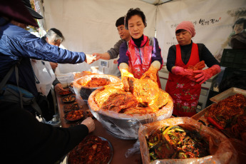 SEÚL, COREA DEL SUR.- Los vendedores de Corea del Sur venden kimchi recién hecho, una guarnición tradicional hecha de repollo y pimienta picante, en el sexto Festival Kimchi de Seúl en el centro de Seúl el 1 de noviembre de 2019. El kimchi es una preparación fermentada de origen coreano que ha ganado mucha popularidad en los últimos años gracias a ser considerado, como todo producto fermentado de origen vegetal, benigno para la salud. Es confeccionado a base de diferentes vegetales sazonados con diferentes especias y cuya receta más extendida utiliza como ingrediente básico la col china, también existen otras recetas en las que se utilizan ingrediente como rábanos o pepinos, entre otros vegetales, que son acompañados comúnmente de pimiento o chile rojo molido, ajos, cebollas u otras combinaciones de acuerdo a diferentes zonas geográficas, pero presente en el día a día de los coreanos, tanto del norte, como los del sur.